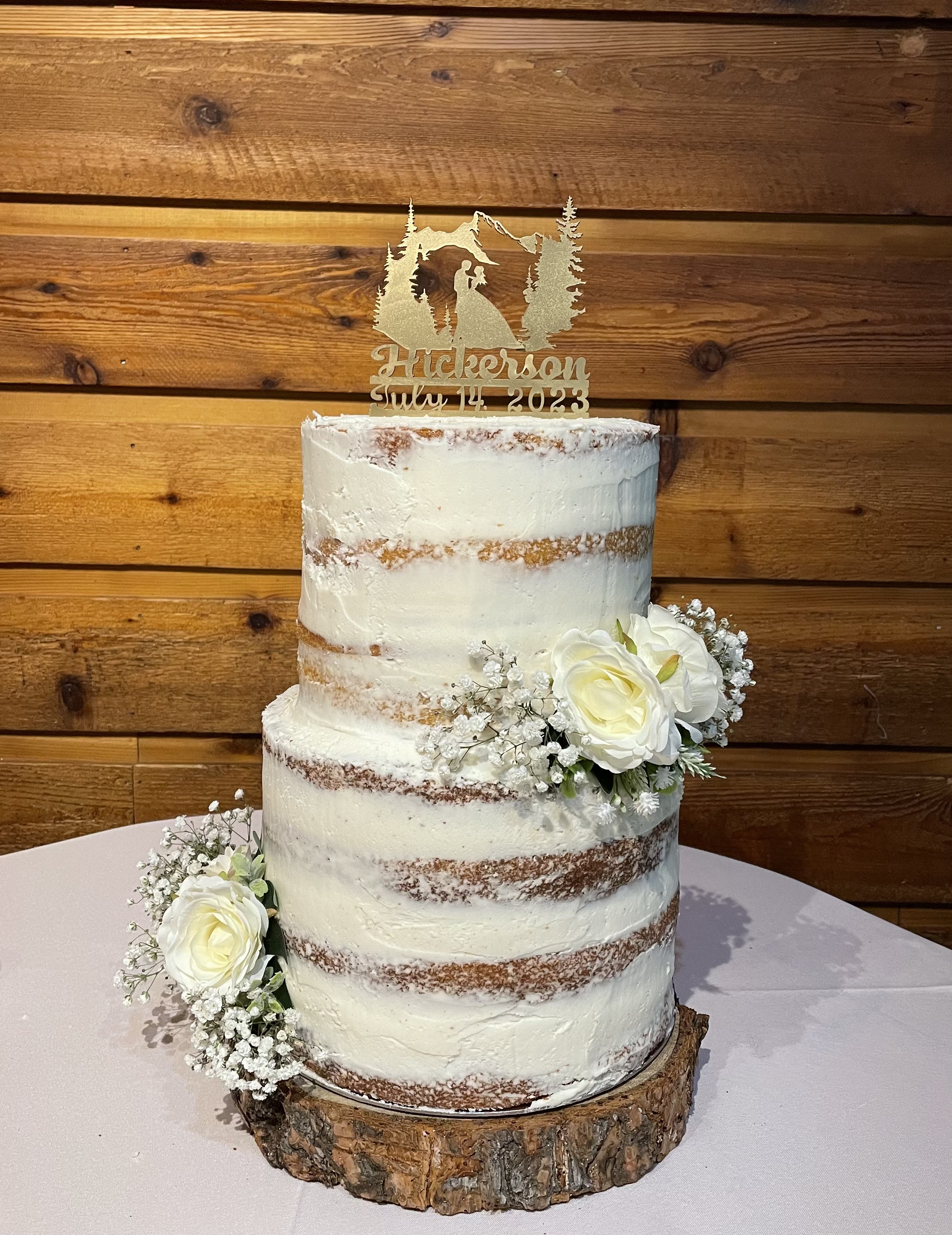 Two tier vanilla wedding cake with flowers.